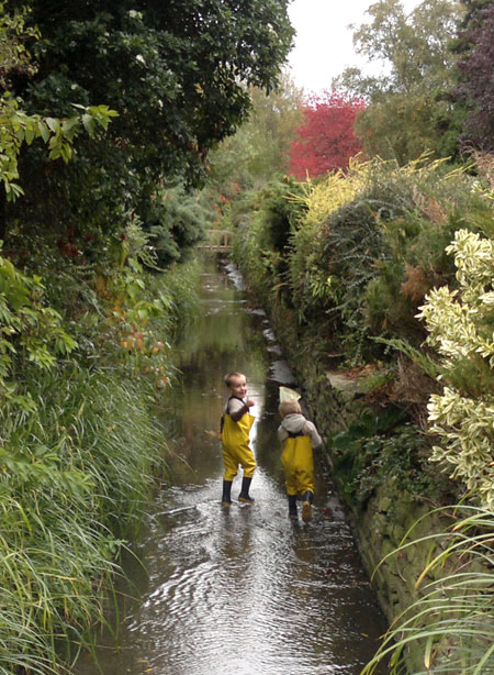 Isaac and Archie playing in a stream in their new kids waders
