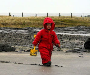 Philip playing in Puddle Suits on the beach